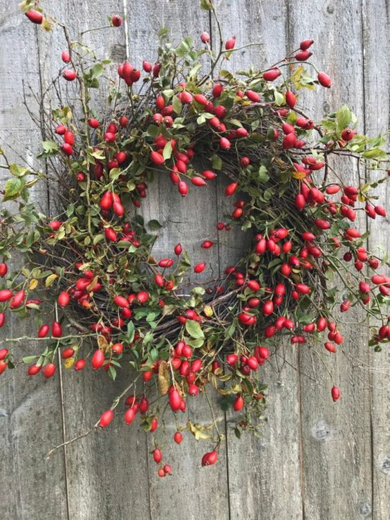 Ein herbstlicher Kranz mit leuchtend roten Farbtupfern.