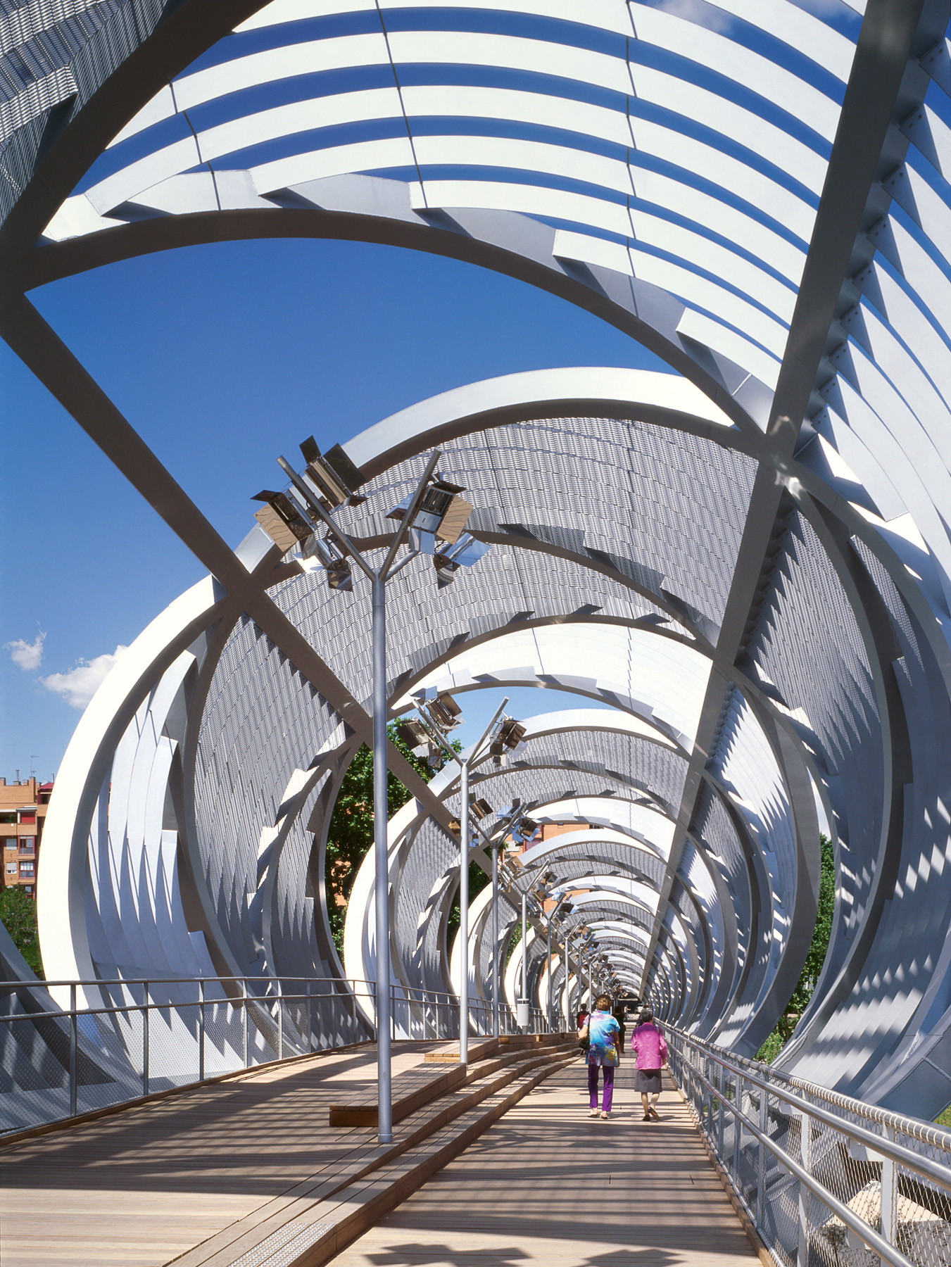Arganzuela-Brücke, Madrid. Wie eine DNA-Doppelhelix spannt sich die 
Arganzuela-Fußgängerbrücke über die Autobahn M30. Das gesamte Bauwerk ist 278 Meter lang und besteht aus Stahl und unterschiedlichen Stahl­geweben, die den Weg teilweise in Schatten hüllen. 