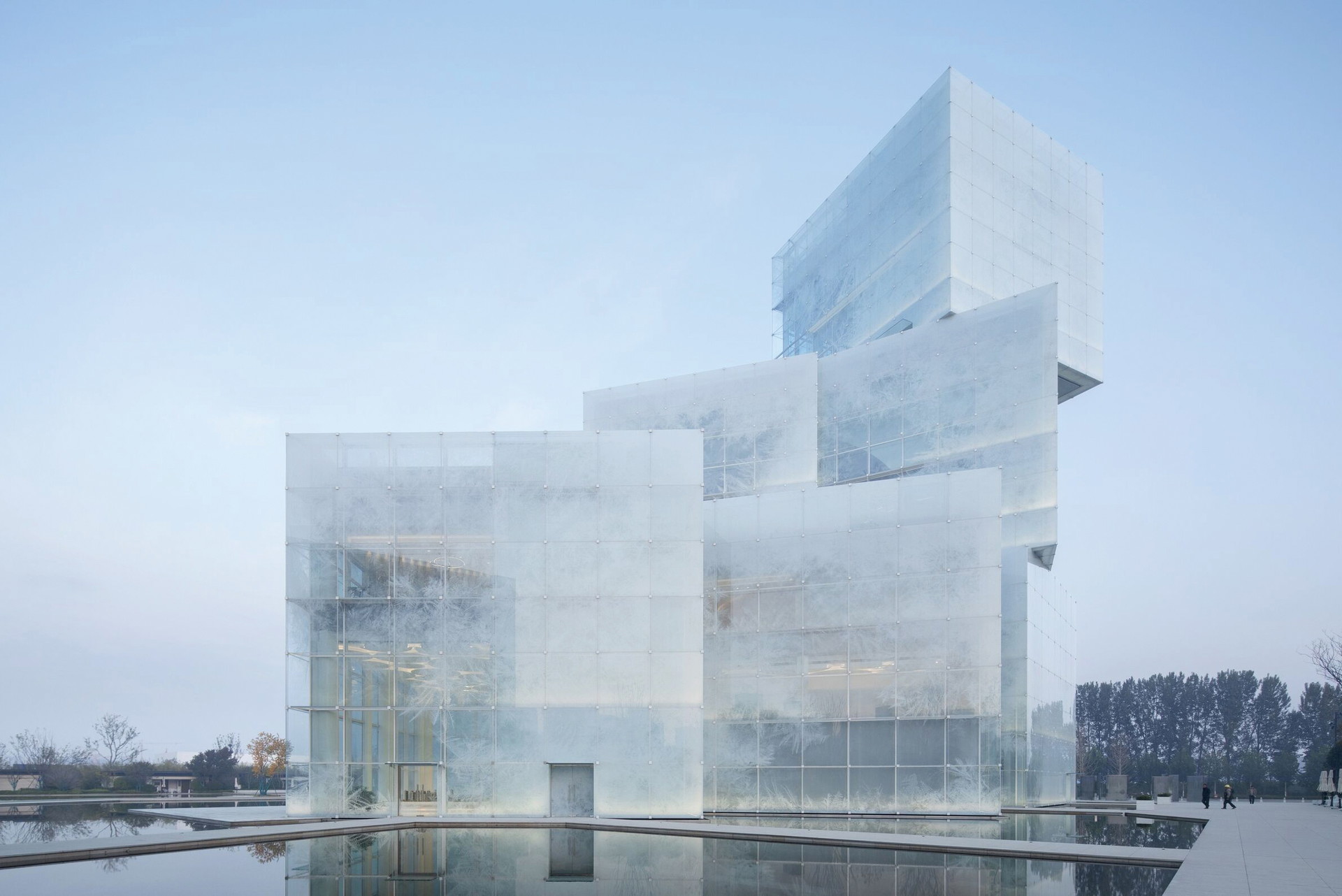 Ice Cubes, Xingxiang. Wie kann man ewige Kälte inszenieren? 
Mit dieser Frage haben sich die beiden 
Büros Zone of Utopia und Mathieu Forest 
Architecte beschäftigt. Das Zhongyuan 
Sunac Kultur- und Tourismuszentrum in 
der chinesischen Provinz Henan orientiert sich an Eiswürfeln und ist in eine 
bedruckte Glasfassade gehüllt 
z-o-u.com, mathieuforest.fr