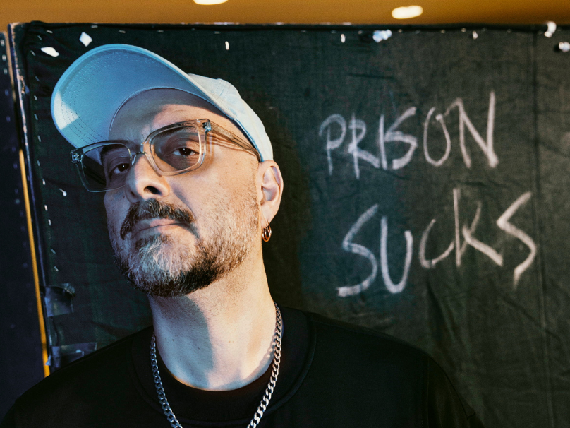 Hintergrund mit Ansage.  Kirill Serebrennikov vor einer zufällig dastehenden Kulissenwand. Er selber war in Moskau in Haft.
