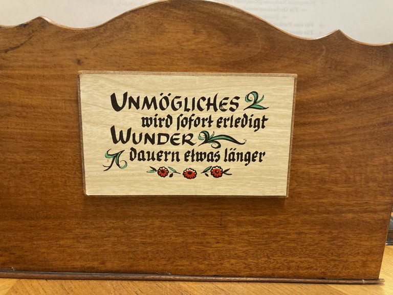 Das Türschild oben ist das Arbeitsmotto des Teams: ­„Unmögliches wird sofort er­ledigt – Wunder dauern etwas länger“. In Zeiten der Pan­demie wurde vor allem der zweite Teil des Spruchs zum Alltag.
