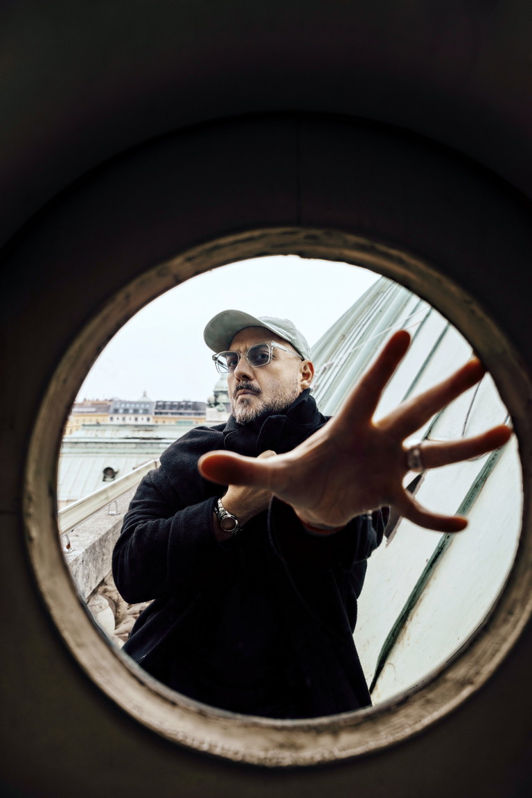 Kirill Serebrennikov, geboren in Rostow am Don, arbeitete u. a. am Bolschoi- und am Mariinski-Theater,  an der Komischen Oper Berlin, für die Wiener Festwochen, er drehte preisgekrönte Filme  (Cannes, Locarno) und wurde 2017 von Putin zuerst verhaftet und dann zu Hausarrest ­verurteilt – von dort aus inszenierte er u. a. via Video 2021 den „Parsifal“ in Wien.  Im Jänner 2022 konnte er ausreisen und lebt seitdem in Berlin im Exil.  Das Foto entstand am Dach der Wiener Staatsoper.