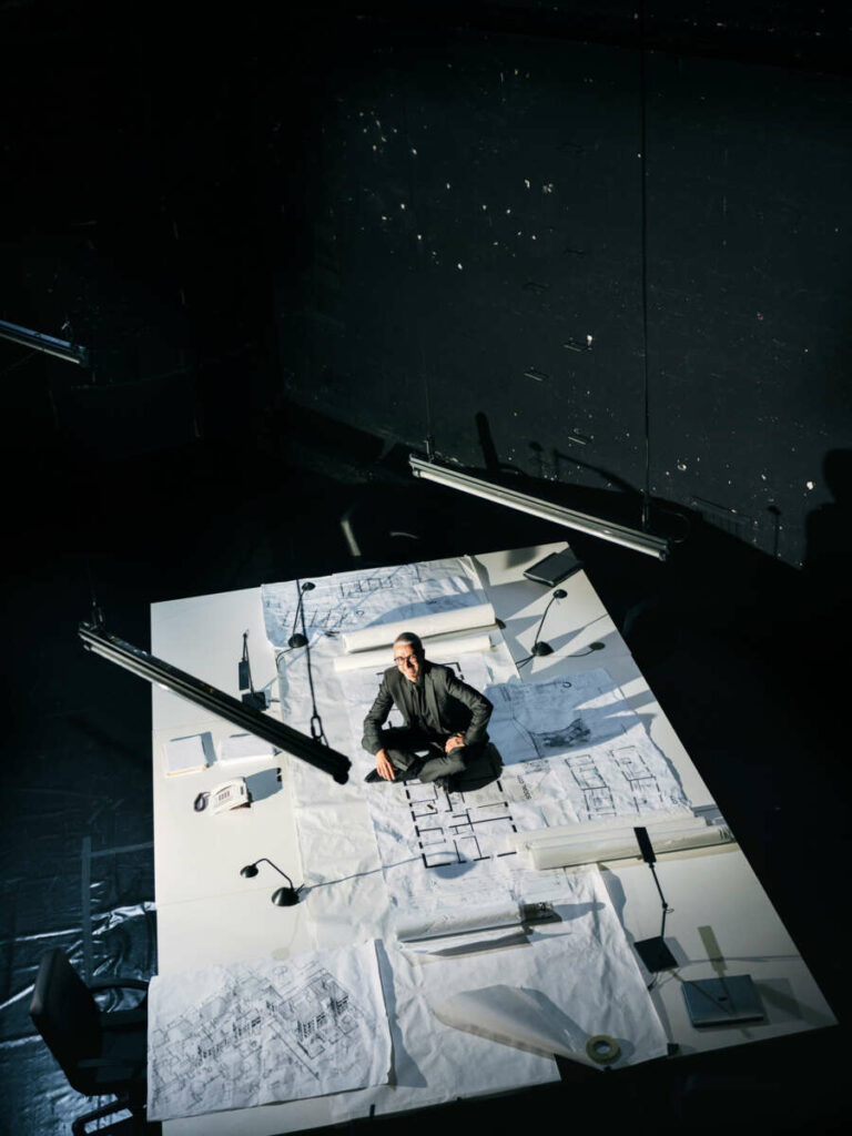 Arbeitsplatz Bühne. Marcello De Nardo, links auf dem Kulissentisch des Henrik-Ibsen-Dramas „Die Stützen der Gesellschaft“, in dem er Dr. Schneider spielt, und backstage pur im schwarzen Anzug. 