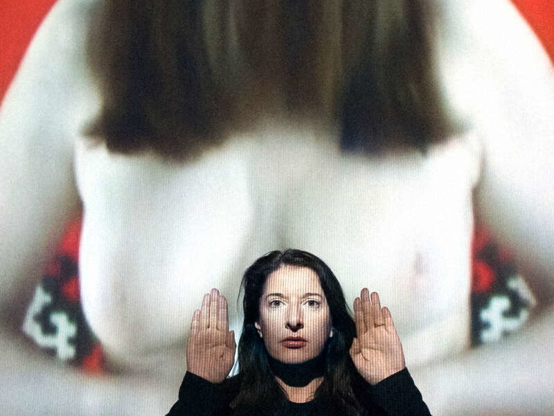 Marina Abramović vor einer Video-Projektion, die sie selber nackt zeigt.