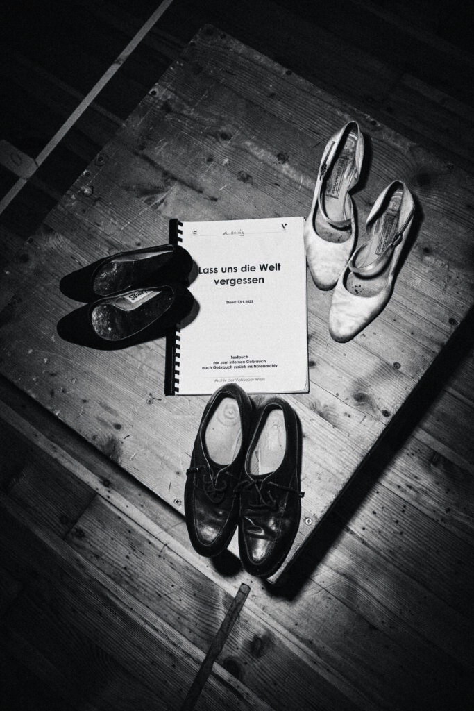Vorbereitung auf der Probebühne. Das Ensemble von heute spielt das Ensemble von damals. Im Bild: Schuhe der Darsteller*innen und das Textbuch.