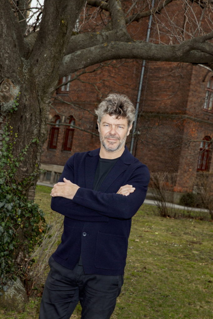 Fotoshooting der BÜHNE.
Anfang März in Wien. Hinter Heras-Casado sind die Wohnungen im Arsenal. Direkt vor ihm ist die Probebühne – sie ist nicht so hübsch wie die Backsteinbauten.